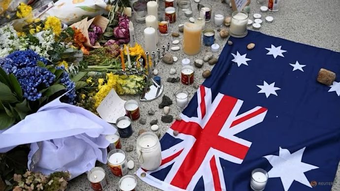 bendera Australia diletakkan di dekat bunga-bunga penghormatan di Pantai Bondi untuk mengenang para korban penembakan massal yang menargetkan perayaan Hanukkah di Pantai Bondi, Sydney, Australia.