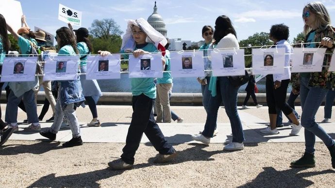Orang-orang memperlihatkan foto-foto korban kekerasan senjata api selama pawai ke Capitol untuk memprotes larangan senjata serbu, di Washington, DC, Amerika Serikat, pada 17 April 2023. ANTARA/XInhua/Aaron Schwartz