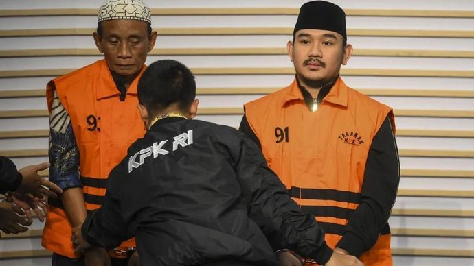 Bupati Bekasi Ade Kuswara Kunang (kanan) bersama ayahnya H. M. Kunang (kiri) dihadirkan saat konferensi pers penahanan usai terjaring operasi tangkap tangan (OTT) di Gedung Merah Putih KPK, Jakarta, Sabtu (20/12/2025). KPK menahan Bupati Bekasi Ade Kuswara Kunang, ayah bupati H. M. Kunang, dan pihak swasta Sarjan setelah ditetapkan tersangka dugaan tindak pidana korupsi terkait suap ijon proyek di Kabupaten Bekasi. ANTARA FOTO/Hafidz Mubarak A/nz