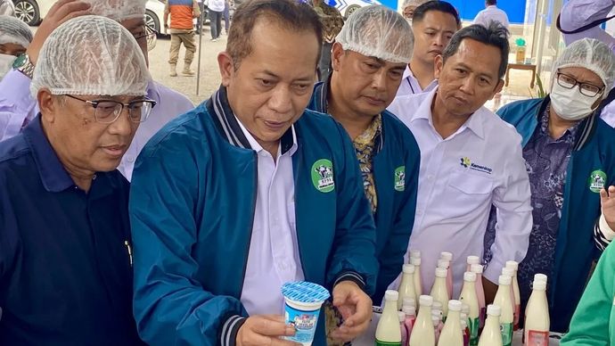 Menteri Koperasi Ferry Juliantono menunjukkan produk susu pasteurisasi saat meninjau pabrik KPBS Pangalengan di Kabupaten Bandung, Jawa Barat, Senin, 22 Desember 2025. (ANTARA/Rizka Khaerunnisa