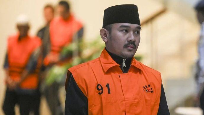 Bupati Bekasi Ade Kuswara Kunang berjalan mengenakan rompi tahanan usai terjaring operasi tangkap tangan (OTT) di Gedung Merah Putih KPK, Jakarta, Sabtu, 20 Desember 2025. KPK menahan Bupati Bekasi Ade Kuswara Kunang, ayah bupati H. M. Kunang, dan pihak swasta Sarjan setelah ditetapkan tersangka dugaan tindak pidana korupsi terkait suap ijon proyek di Kabupaten Bekasi. ANTARA FOTO/Hafidz Mubarak A/rwa.