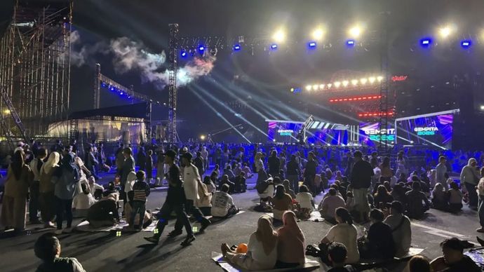 Pengunjung Ancol menikmati hiburan konser yang digelar di panggung yang berada di Pantai Karnaval, Ancol, Jakarta Utara,