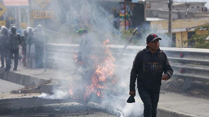 Seorang pria berjalan lewat di samping penghalang yang sedang terbakar yang dinyalakan oleh para demonstran di Quito, Ekuador, 16 September 2025. ANTARA/Xinhua/Ricardo Landeta/aa.