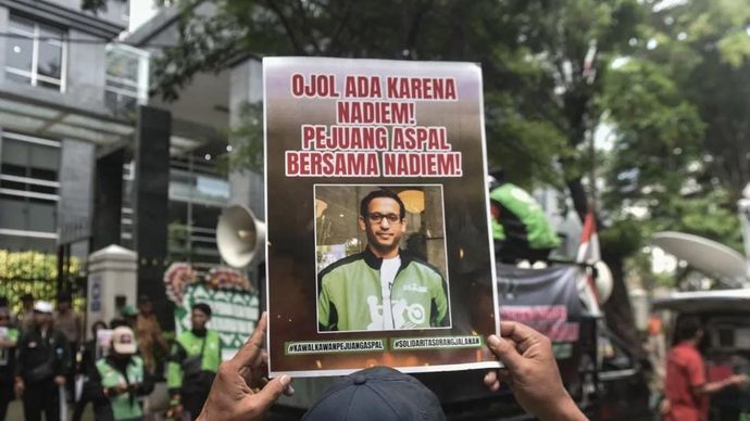 Pengemudi ojek daring memegang poster dukungan kepada tersangka kasus dugaan korupsi dalam digitalisasi pendidikan dan pengadaan laptop Chromebook di Kemendikbudristek tahun di 2019-2022 Nadiem Makarim di depan PN Jakarta Pusat, Senin 5 Januari 2026. ANTARA FOTO/Fakhri Hermansyah/YU.
