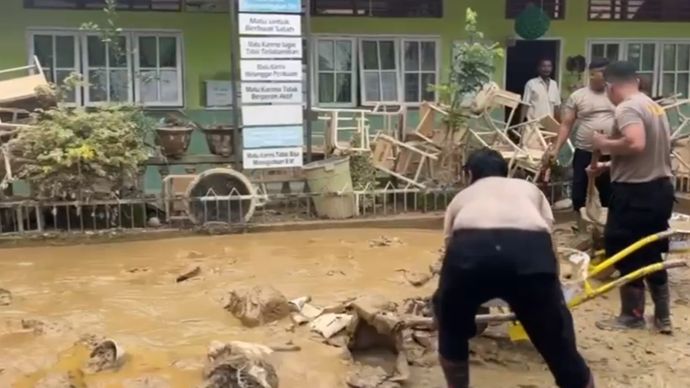 Polisi bersihkan sekolah di Aceh Tamiang. 