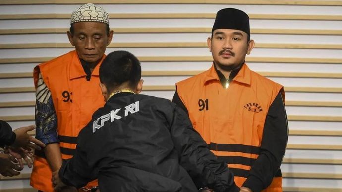Bupati Bekasi Ade Kuswara Kunang (kanan) bersama ayahnya H. M. Kunang (kiri) dihadirkan saat konferensi pers penahanan usai terjaring operasi tangkap tangan (OTT) di Gedung Merah Putih KPK, Jakarta, Sabtu 20 Desember 2025. ANTARA FOTO/Hafidz Mubarak A/nz/am.