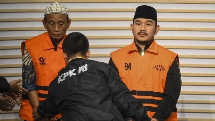 Bupati Bekasi Ade Kuswara Kunang (kanan) bersama ayahnya H. M. Kunang (kiri) dihadirkan saat konferensi pers penahanan usai terjaring operasi tangkap tangan (OTT) di Gedung Merah Putih KPK, Jakarta, Sabtu 20 Desember 2025. ANTARA FOTO/Hafidz Mubarak A/nz/am.