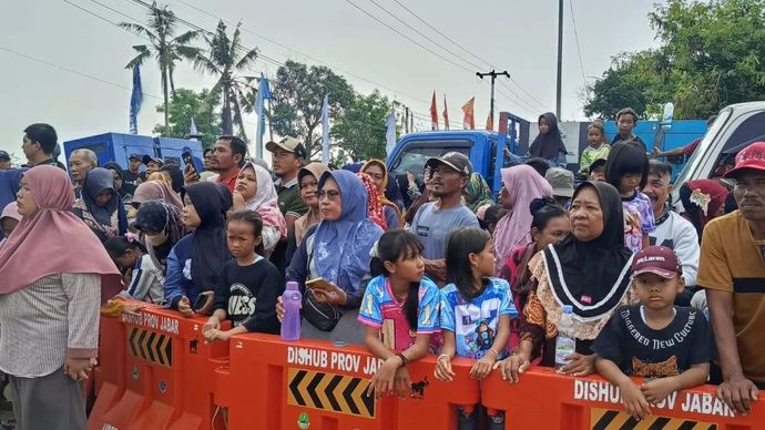 Warga menyaksikan kunjungan Presiden Republik Indonesia Prabowo Subianto di Karawang. ANTARA/Ali Khumaini