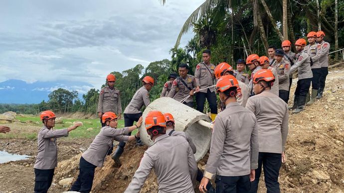 Anggota Satuan Brimob Polda Sumatra Barat memperbaiki gorong-gorong dan akses jalan yang terputus akibat banjir di Jorong Koto Tangah, Nagari Koto Alam Seberang Aia, Kecamatan Palembayan, Kabupaten Agam. 