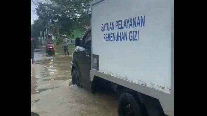 Mobil SPPG terabas banjir demi antar bantuan makanan bergizi. 