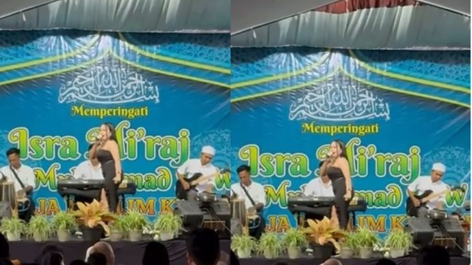Seorang biduan perempuan berjoget dan bernyanyi di atas panggung acara peringatan Isra Miraj Nabi Muhammad SAW di Kecamatan Songgon, Banyuwangi.