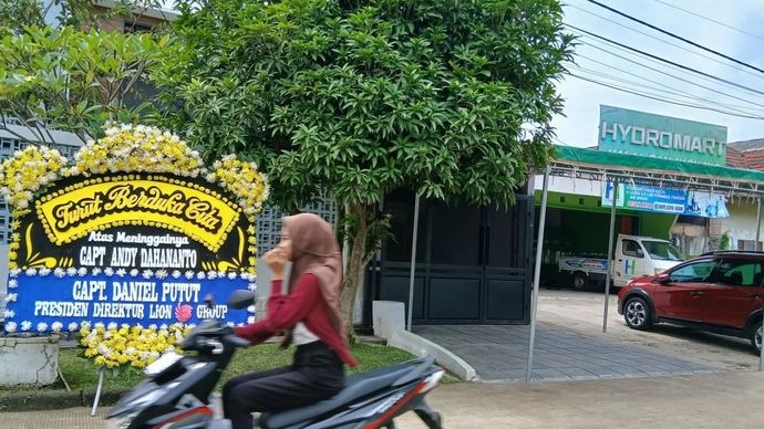 Pengendara melintas di rumah duka Capt. Andy Dahananto salah satu pilot senior pesawat ATR 42-500 milik Indonesia Air Transport (IAT) yang merupakan salah satu korban kecelakaan udara di Gunung Bulusaraung, Kabupaten Maros, Sulawesi Selatan pada Sabtu, 17 Januari 2026. ANTARA/Azmi Samsul M