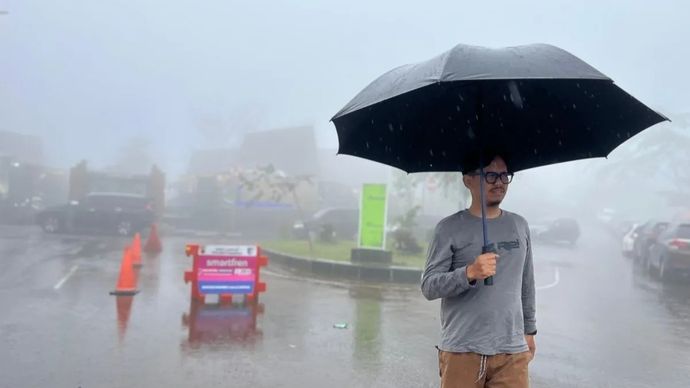 Masyarakat menggunakan payung saat hujan di Rest Area Gunung Mas, Cisarua, Kabupaten Bogor, Jawa Barat, Jumat, 23 Januari 2026. ANTARA/M Fikri Setiawan