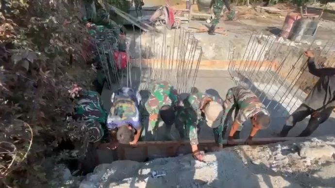 TNI dan warga bergotong royong untuk mengangkut material dan mengecor fondasi jembatan, di Desa Burni Bius, Kecamatan Silih Nara, Aceh, pada Sabtu, 31 Januari 2026.