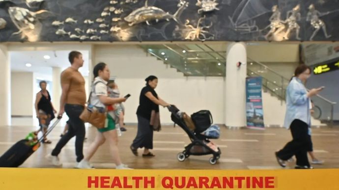 Penumpang pesawat berjalan melewati area pemeriksaan Balai Besar Kekarantinaan Kesehatan Kelas I Denpasar di Terminal Internasional Bandara Internasional I Gusti Ngurah Rai, Badung, Bali, Kamis, 29 Januari 2026. Pengelola Bandara Bali bersama dengan 