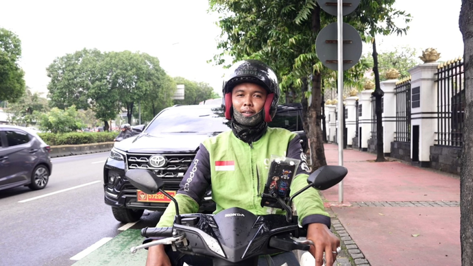 Seorang pengemudi ojek online menunggu penumpang di jalan ibu kota. Pemerintahan Presiden **Prabowo Subianto** kembali menetapkan kebijakan Bonus Hari Raya (BHR) bagi mitra pengemudi ojol.