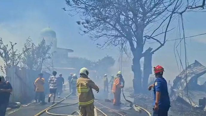 Petugas bersama warga berjibaku memadamkan kebakaran beberapa bangunan di Jalan Kamal Raya, Tegal Alur, Kalideres, Jakarta Barat, Rabu (18/3/2026) siang. ANTARA/Risky Syukur