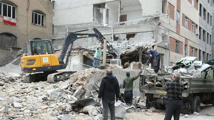 Warga membersihkan puing-puing di antara bangunan yang hancur di daerah pemukiman di Teheran, Iran, 15 Maret 2026. ANTARA/Xinhua/Shadati/pri.