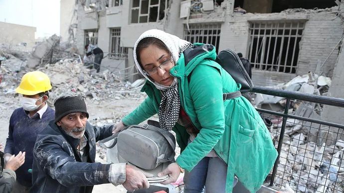 Orang-orang mengangkut barang-barang yang berhasil diselamatkan dari rumah-rumah yang hancur akibat serangan udara Israel di Teheran, Iran, Kamis 12 Maret 2026. ANTARA/Xinhua/Shadati/aa.