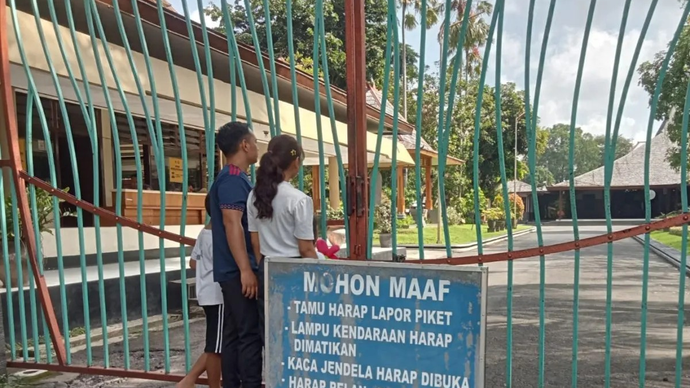 Sepasang muda mudi melihat suasana dalam dari sisis luar pintu gerbang Pendopo Kongas Arum Kusumaning Bongso di Tulungagung, Jawa Timur, Minggu (12/4/2026). Destyan Sujarwoko