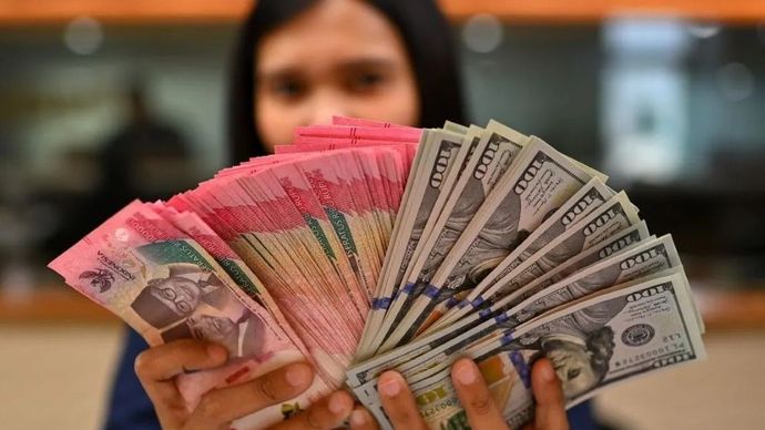 Karyawan memperlihatkan uang pecahan rupiah dan dolar Amerika Serikat (AS) di gerai penukaran mata uang asing Ayu Masagung, Jakarta, Selasa (12/5/2026). (Foto: ANTARA FOTO/Indrianto Eko Suwarso/kye)
