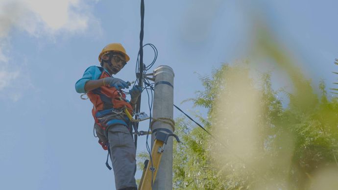 Petugas PLN melakukan penyambungan listrik tegangan rendah agar dapat melistriki rumah rumah masyarakat di Dusun Noemuke.