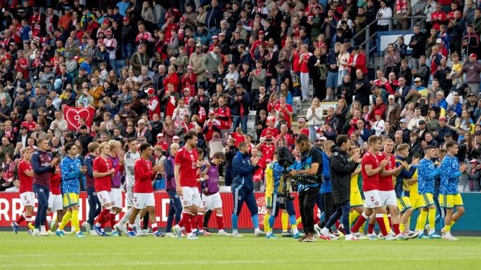 Para pemain timnas Denmark dan Ukraina menyapa penonton setelah gelandang Denmark Christian Eriksen mendapatkan perawatan pascakolaps pada babak kedua laga persahabatan di Stadion Odense, Denmark, Minggu (7/6/2026). (ANTARA/AFP/Bo Amstrup)