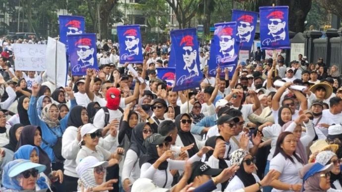 Sejumlah simpatisan MBG Malang Raya membawa umbul-umbul bergambar wajah Presiden Prabowo Subianto saat pelaksanaan "Apel Akbar dan Senam Bersama" di Alun-Alun Tugu, Kota Malang, Jawa Timur, Sabtu (20/6/2026). (Foto: ANTARA/Ananto Pradana)
