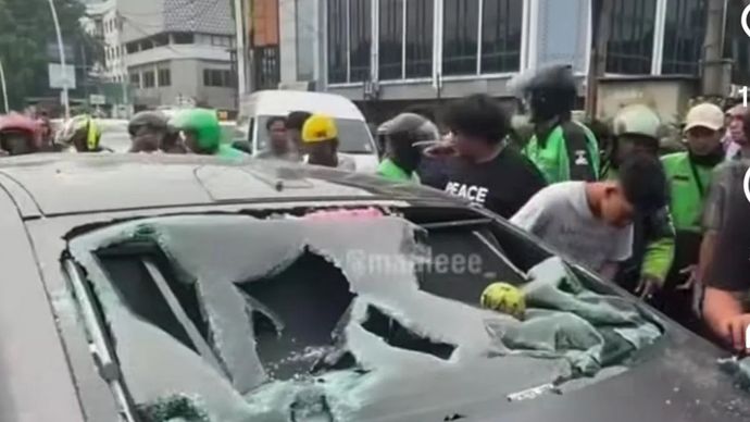 Sebuah mobil listrik menjadi sasaran amukan massa usai diduga menabrak seorang pengendara sepeda motor di Jalan Meruya Selatan, tepatnya Universitas Mercu Buana, Kembangan, Jakarta Barat, Senin, 22 Juni 2026.