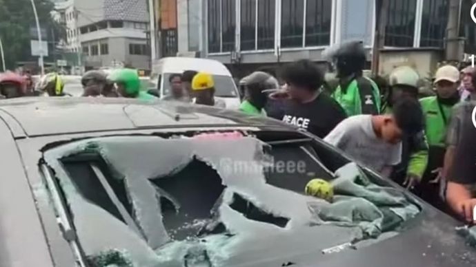 Tangkapan layar - sebuah mobil listrik menjadi sasaran amukan massa usai diduga menabrak seorang pengendara sepeda motor di Jalan Meruya Selatan, tepatnya Universitas Mercu Buana, Kembangan, Jakarta Barat, Senin, 22 Juni 2026.