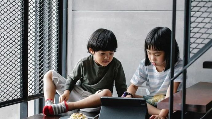 Ilustrasi - Dua orang anak sedang bermain game online di gawai. 