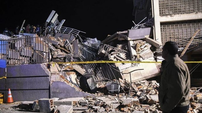 Warga menyaksikan para petugas penyelamat bekerja di reruntuhan sebuah bangunan setelah gempa bumi berkekuatan magnitudo 7,1 mengguncang Caracas, Venezuela, Rabu, 24 Juni 2026 waktu setempat.