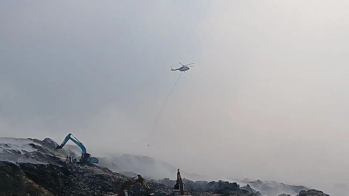 Petugas dan sejumlah alat berat beraktivitas di area kebakaran TPA Jatiwaringin, Mauk, Kabupaten Tangerang, untuk melakukan pemadaman pada Jumat, 3 Juli 2026