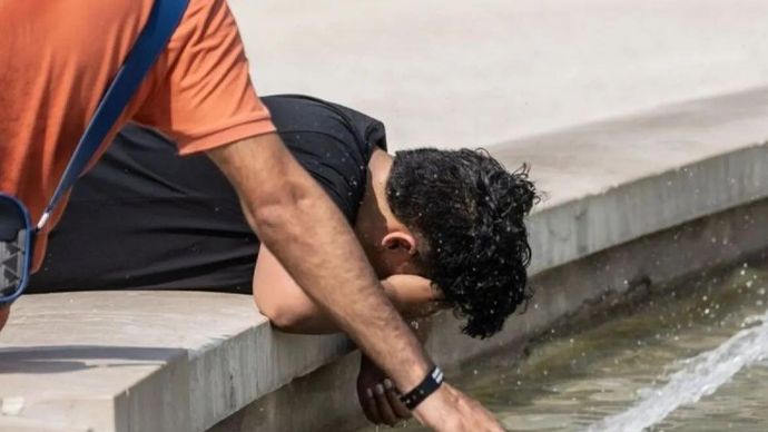 Warga menyejukkan diri di air mancur umum untuk mengatasi suhu tinggi selama gelombang panas ekstrem yang memicu peringatan di 17 kota di seluruh negeri, di Milan, Italia