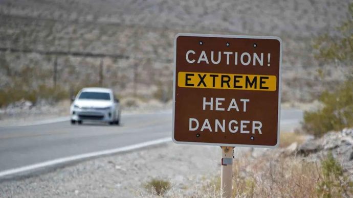 Sebuah papan peringatan tentang bahaya cuaca panas ekstreme terpasang di Pos Pusat Pengunjung Furnace Creek, Taman Nasional Death Valley, California, Amerika Serikat, Senin, 17 Agustus 2020