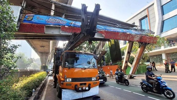 Truk angkut alat berat (crane) tersangkut jembatan penyeberangan orang (JPO) di Jalan Kapten Tendean di kawasan Mampang Prapatan, Jakarta Selatan, Selasa, 14 Juli 2026