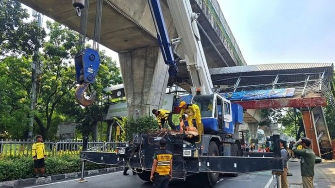 Personel Suku Dinas Bina Marga Jakarta Selatan mengerahkan crane tadano untuk membongkar jembatan penyeberangan orang (JPO) Tendean, Jakarta, Selasa, 14 Juli 2026. 
