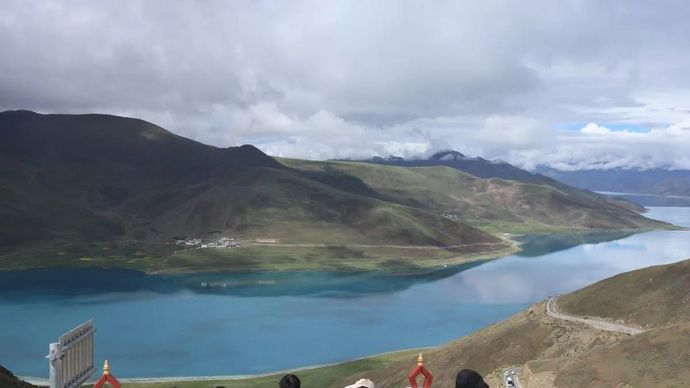 Turis menikmati keindahan Danau Yamdrok yang berada di lereng utara Himalaya, masuk di bawah administrasi Kota Shannan, Daerah Otonom Xizang, China, Jumat, 24 Juli 2026. Danau yang berada di ketinggian 4.441 meter di atas permukaan laut tersebut terkenal karena punya berbagai variasi warna biru dan juga menjadi danau suci bagi umat Buddha Tibet sehingga terlarang untuk berenang, memancing atau kegiatan lain.