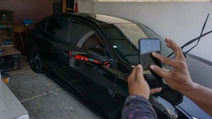 Seorang wartawan memotret mobil yang disegel KPK di salah satu rumah di Kabupaten Pemalang, Jawa Tengah, Rabu (29/7/2026). KPK menyegel kantor Kepala Dinas Pekerjaan Umum dan Penataan Ruang (PUPR) Pemalang dan dua rumah terkait adanya operasi tangkap tangan (OTT) yang menyeret Bupati Pemalang Anom Widiyantoro pada Selasa, 28 Juli 2026. 