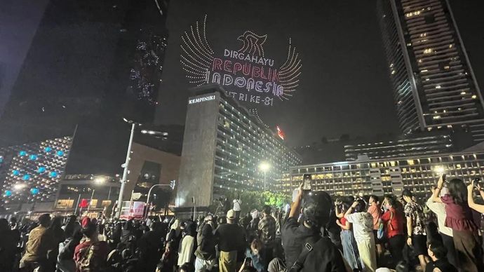 Masyarakat mengabadikan momen pertunjukan atraksi drone yang menampilkan ilustrasi bercerita perjalanan Indonesia dalam memperingati Hari Ulang Tahun (HUT) ke-81 Kemerdekaan Republik Indonesia, mewarnai langit Bundaran HI, Jakarta