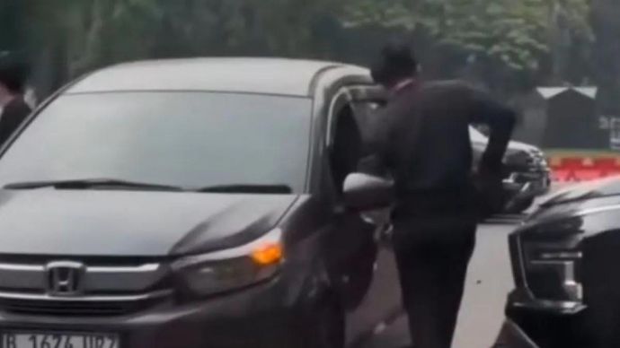 Tangkapan layar dari media sosial Instagram melalui akun @kabarjakartaterkini yang memperlihatkan kedua orang masuk ke dalam sebuah kolong mobil tanpa diketahui apa yang sedang mereka lakukan