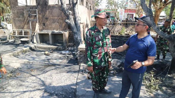 Kepala Dinas Kebudayaan NTB Muhamad Ihwan (kanan) berdialog dengan aparat keamanan saat meninjau kondisi pasca kebakaran yang melanda Kampung Adat Sade di Lombok Tengah, Nusa Tenggara Barat