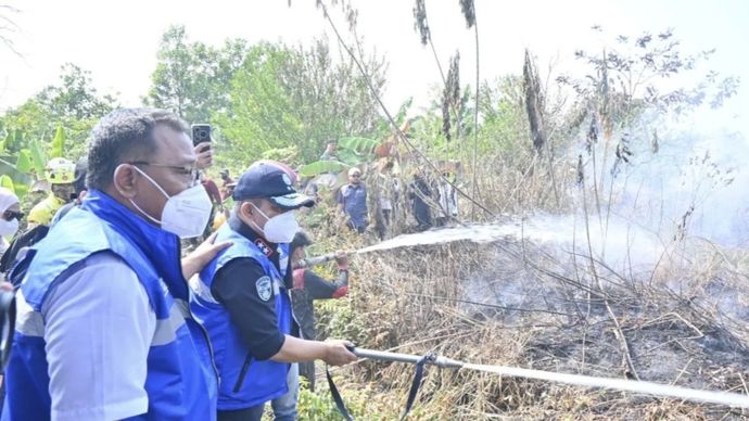 Deputi Bidang Penegakan Hukum Lingkungan Hidup KLH Irjen Pol Rizal Irawan (kedua kiri) mendampingi Menteri LH Mohammad Jumhur Hidayat (kiri) memadamkan kebakaran hutan dan lahan (karhutla) di kawasan Jalan Kurnia, Landasan Ulin Barat, Banjarbaru, Kalimantan Selatan