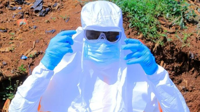 Seorang petugas kesehatan mengenakan alat pelindung diri sebelum mengangkut jenazah seseorang yang meninggal karena diduga terinfeksi Ebola di desa Mongbwalu, provinsi Ituri, di bagian timur Republik Demokratik Kongo, pada 25 Mei 2026. 