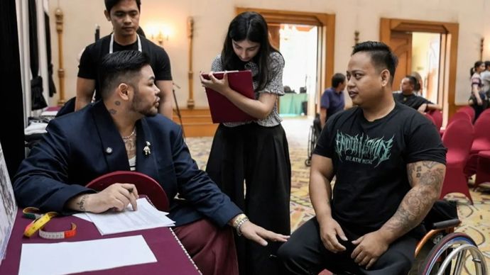 Perancang busana Ivan Gunawan (kiri) mengukur tubuh salah satu atlet disabilitas untuk pembuatan seragam defile kontingen Indonesia dalam Asian Para Games 2026 Aichi-Nagoya, Jepang.