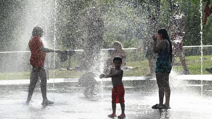 Orang-orang mendinginkan diri di air mancur di tengah gelombang panas di sebuah taman di Madrid, Spanyol, Rabu, 24 Mei 2026