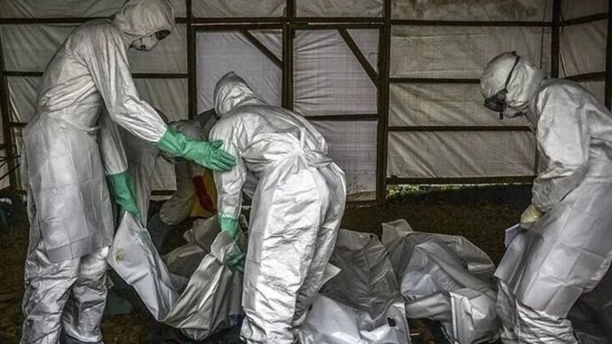 Arsip foto - Para sukarelawan muda melakukan disinfeksi terhadap jenazah korban virus Ebola sebelum dimakamkan. 