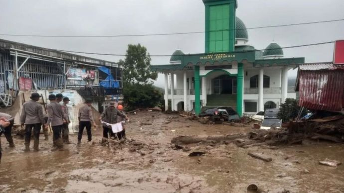 Material banjir bandang berupa lumpur yang menutupi halaman masjid di sekitar kompleks perkantoran bupati Solok, Sumatera Barat.