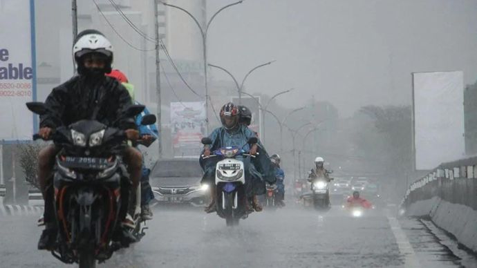 Ilustrasi - Sejumlah pengendara menerobos hujan di Makassar, Sulawesi Selatan.