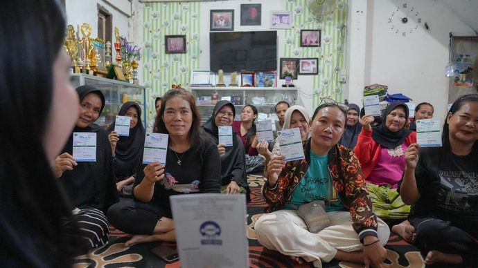 Nasabah PNM Mekaar dengan bangga menunjukkan dokumen pembiayaan mereka. 